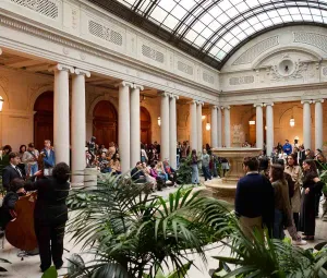 Visitors enjoying First Fridays events at The Frick Collection in the Garden Court with live music