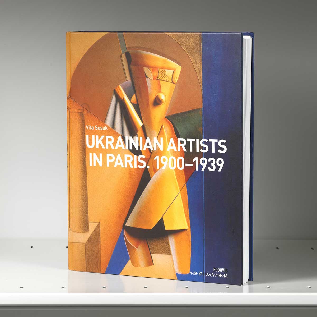 Book on a shelf whose cover featured an abstract yellow Cubist figure