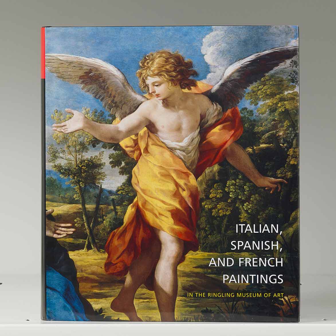 Book cover on a white shelf featuring a painting of a winged angel in yellow drapery
