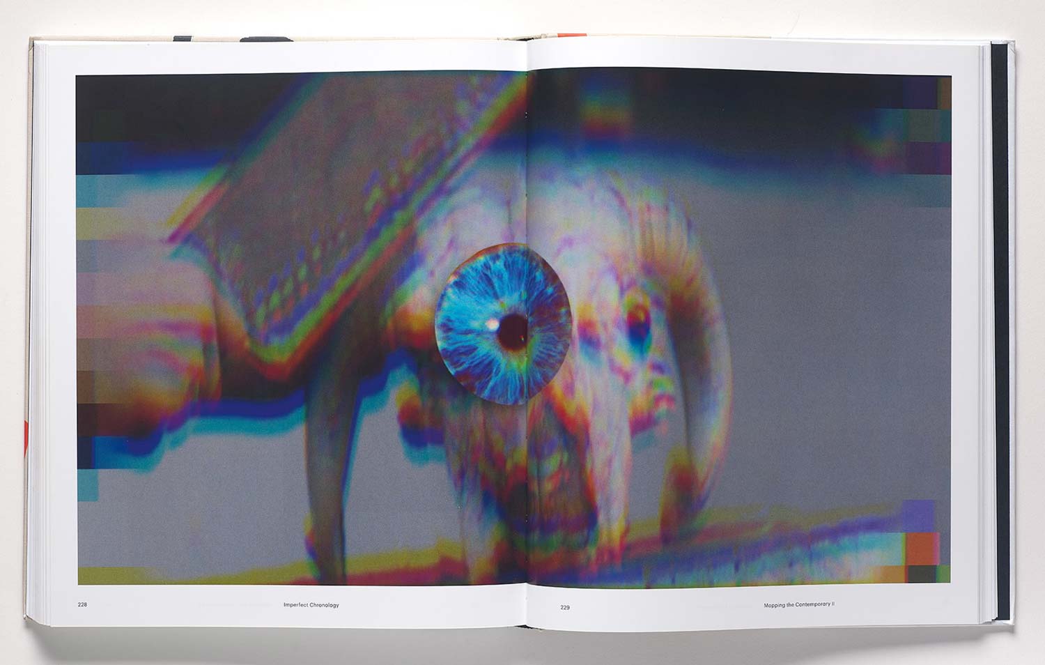 Book spread showing a digital artwork of a knife cutting an eyeball