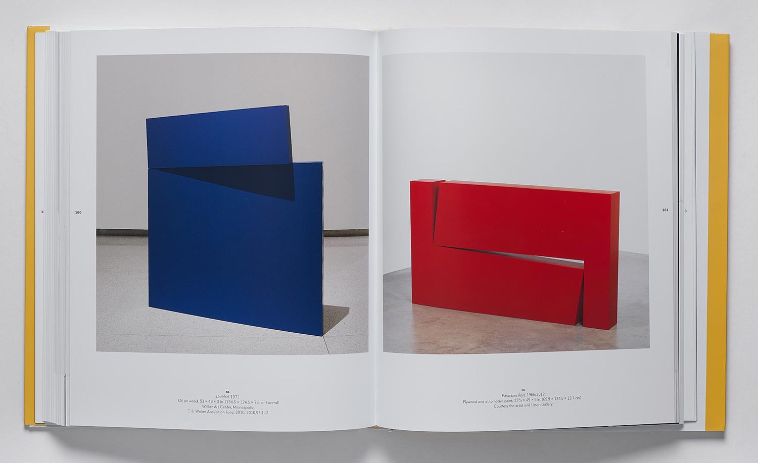 Book spread featuring a blue and a red geometric sculpture