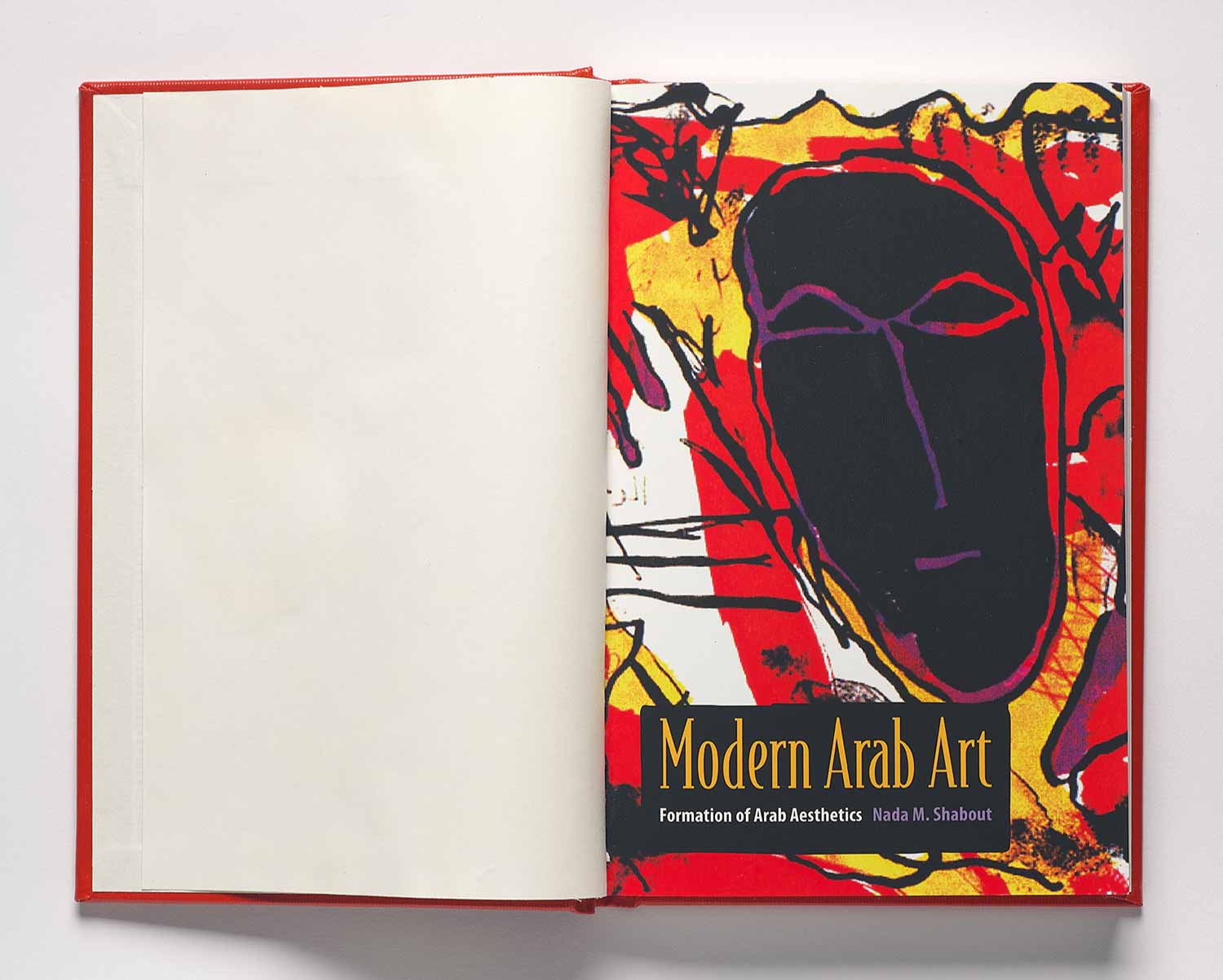 Book open to a cover page featuring a colorful artwork with a black masklike face