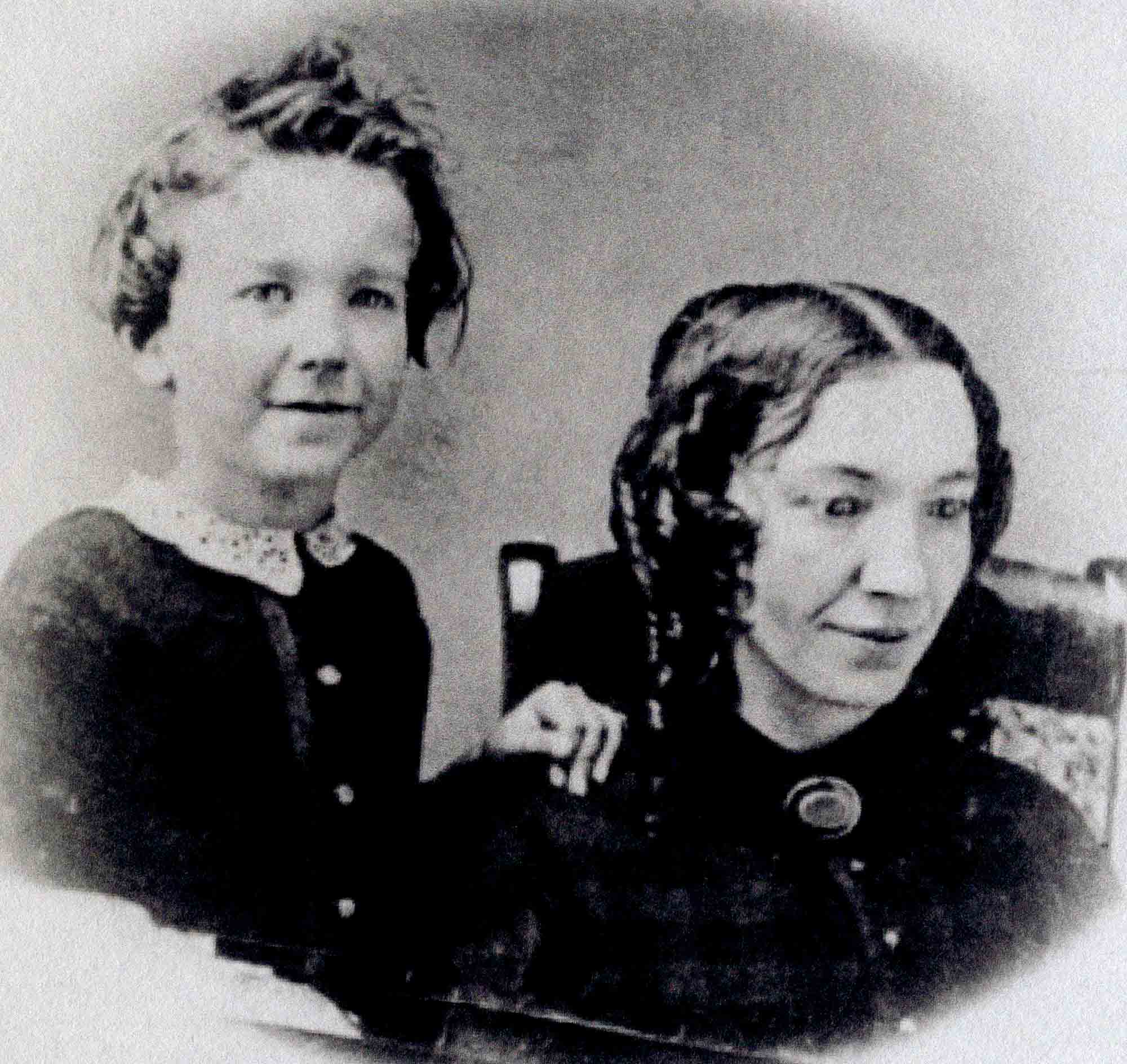 Nineteenth-century photograph of a mother, seated, with her young son standing beside her.