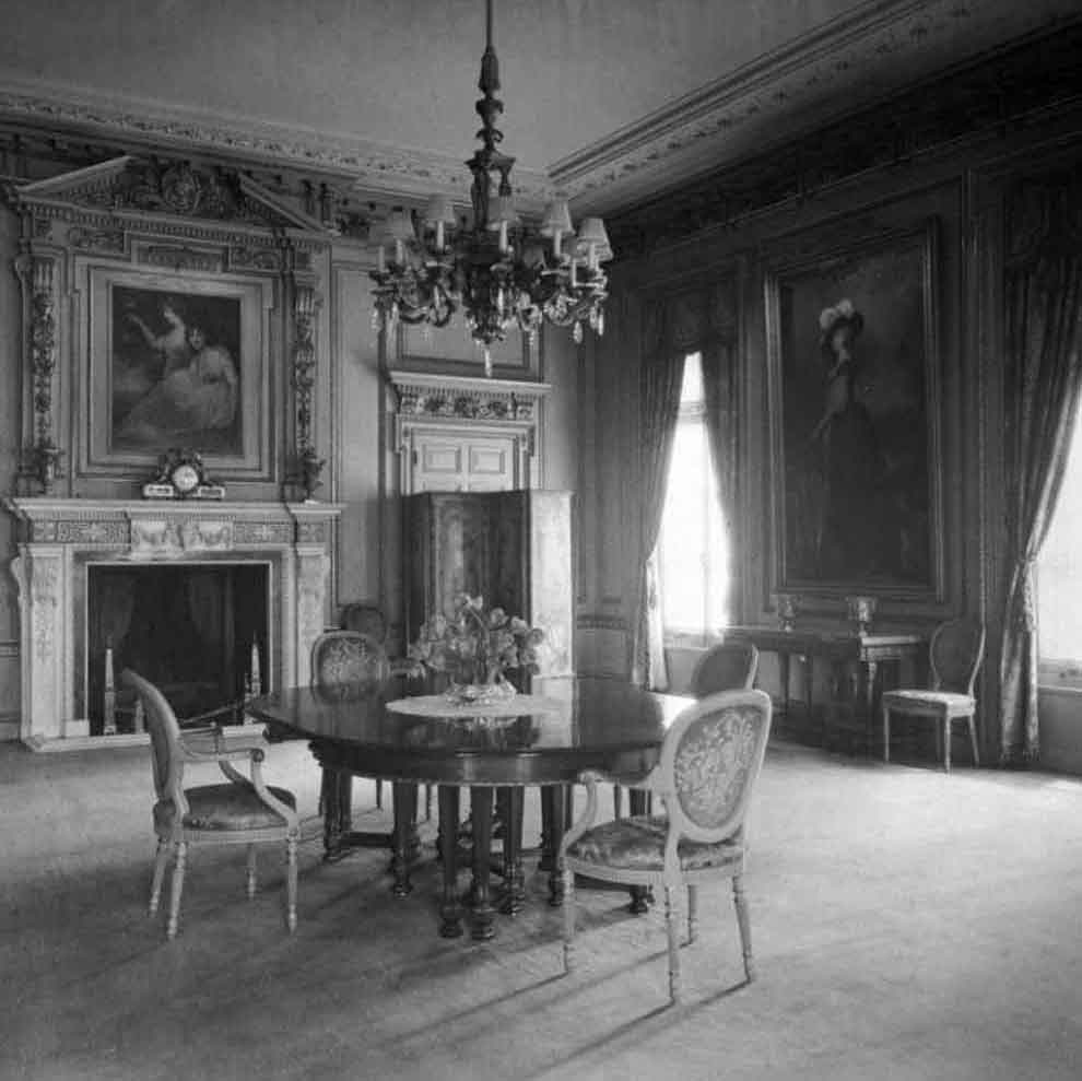 black and white photo of house setting with table and chair and table at center