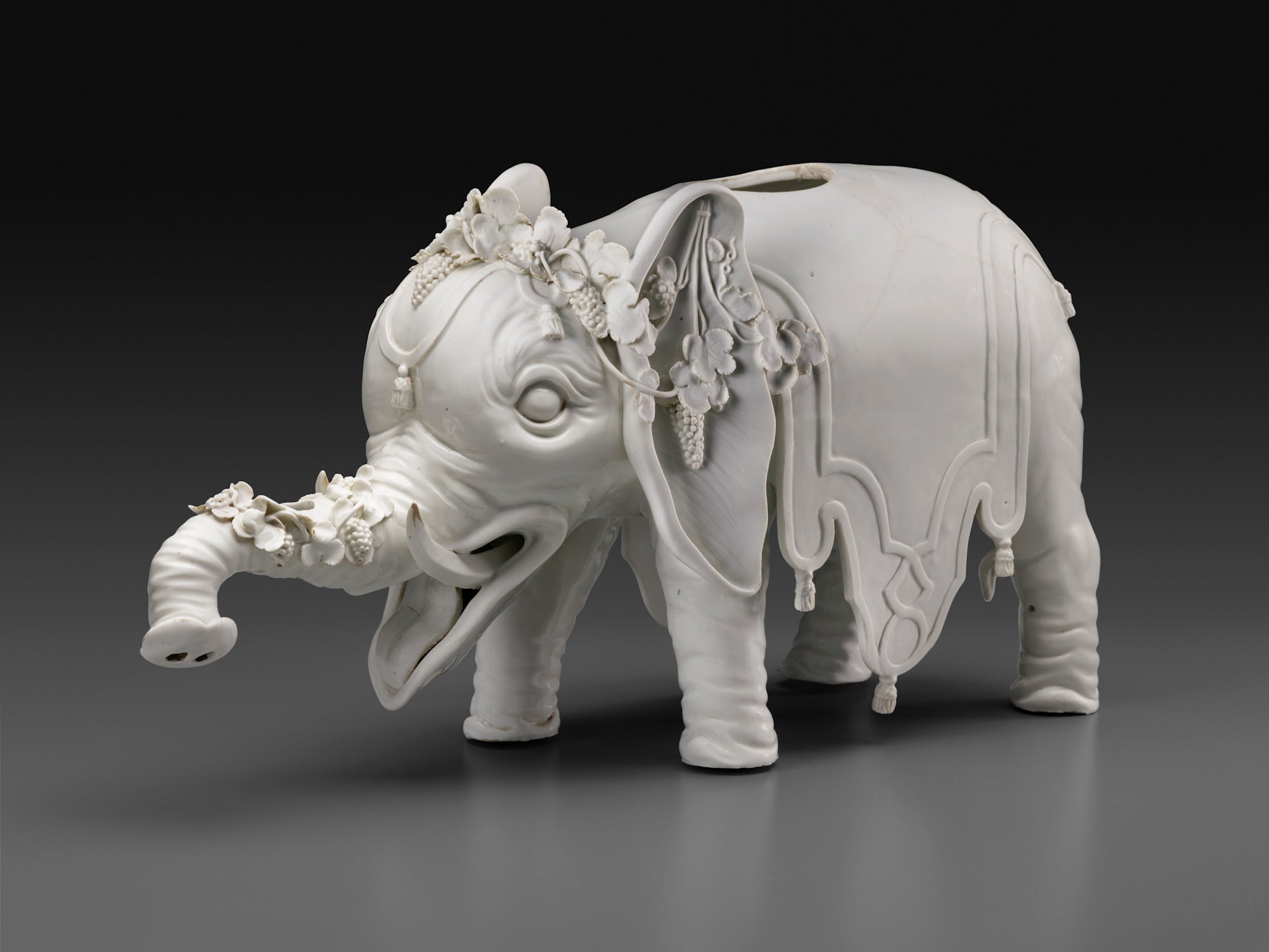photo of gray porcelain elephant statue decorated with flowers and draperies