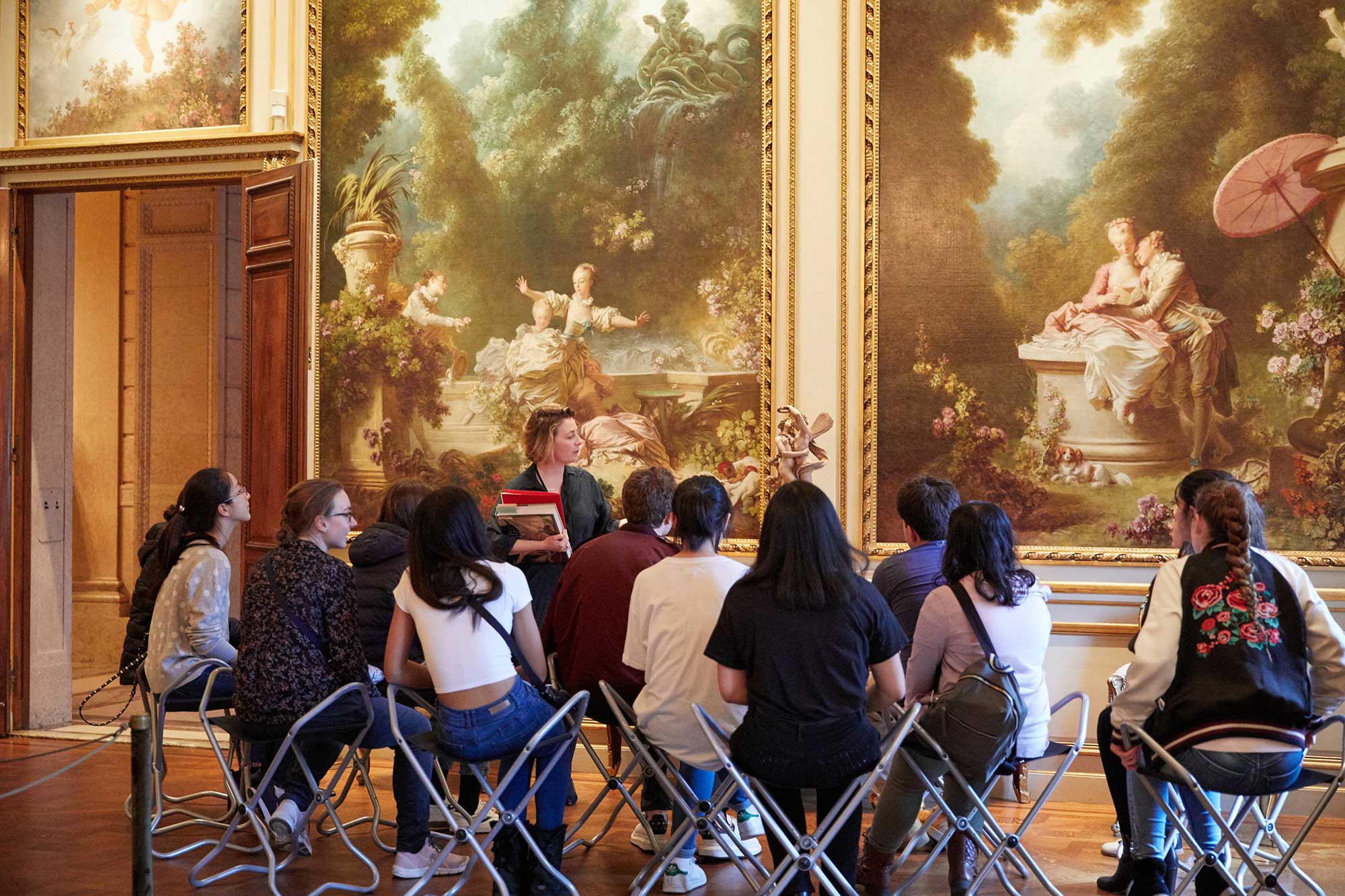 students in the Frick Collection gallery, with educator standing in front of paintings