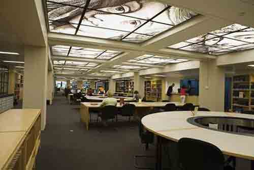 A view into a large study room featuring round tables and skylights.