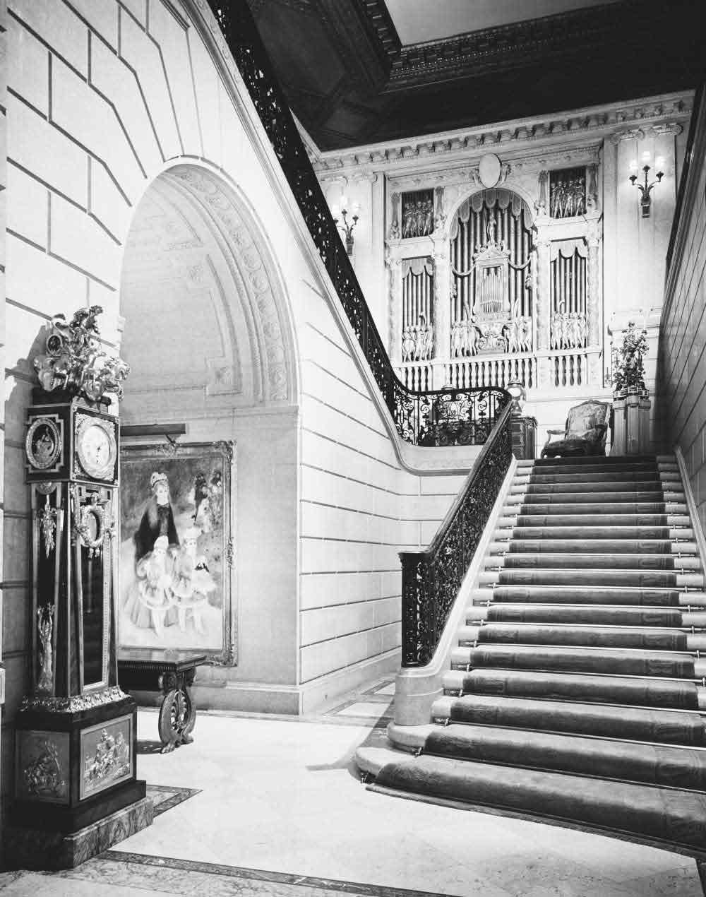 Carpeted staircase at The Frick Collection with ornate organ screen at the top