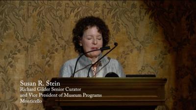 video still of Susan Stein giving lecture at podium