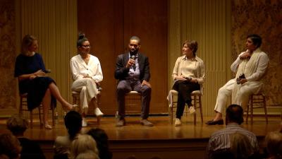 video still of five panelists seated on stage