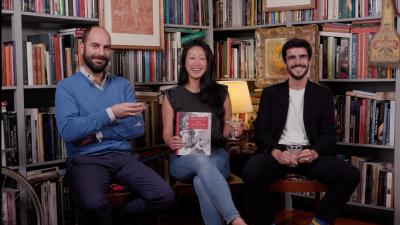 video still of Xavier F. Salomon, Aimee Ng, and Giulio Dalvit sitting with glasses among bookcases