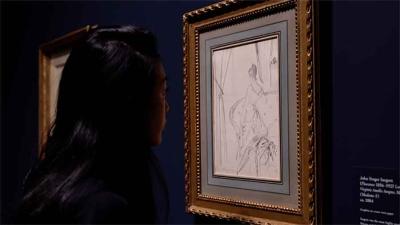 video still of Aimee Ng looking at drawing of woman closely