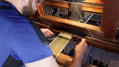 video still of man working with loom