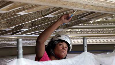 Woman repairing ceiling