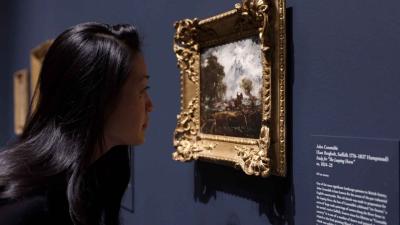 video still of Aimee Ng looking closely at painting