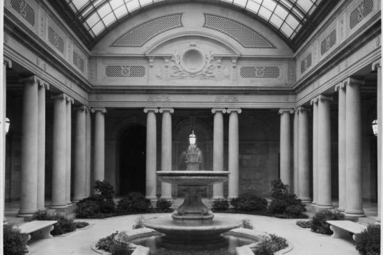 black and white photograph of frick garden court showing interior fountain surrounded by columns with skylight above