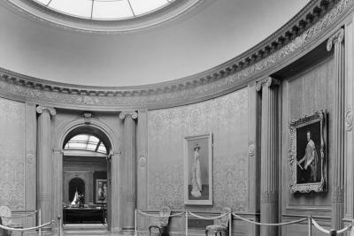 photo of oval shaped room with skylight, paintings, and rope, circa 1935