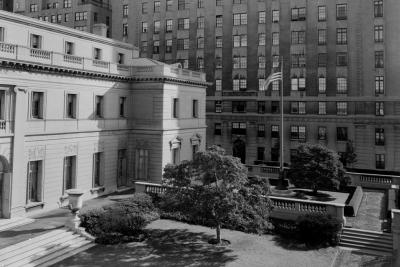 photo of garden in front of building with U.S.A. flag near building, circa 1955
