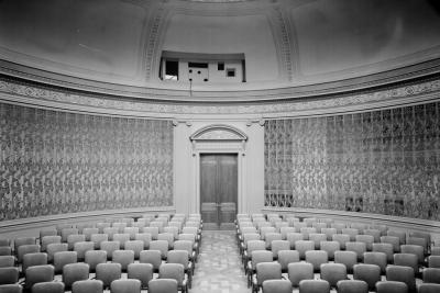 photo of round room with empty chairs and aisle leading to doorway, circa 1966