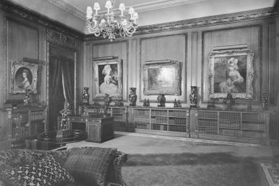 photo of library room with paintings, short bookcases, chandelier, and couch, circa 1942