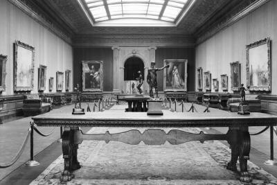 photo of gallery with sculptures on tables, paintings, skylight and barrier roping, circa 1942