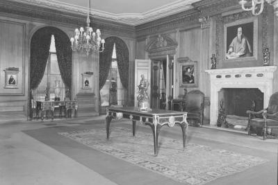 photo of room with paintings, fireplace, tables, chandeliers, circa 1952