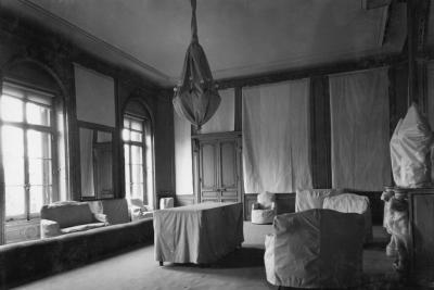 photo of room with white protective covering over furniture, walls and lighting fixture, circa 1935