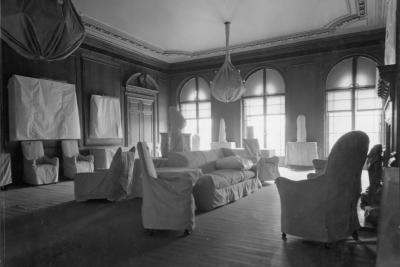 photo of room with white protective covering over furniture, walls and lighting fixture, circa 1933