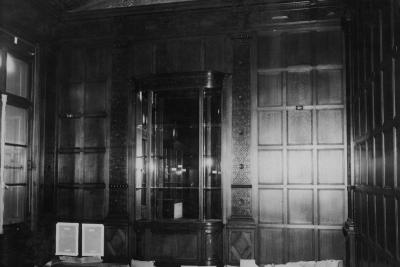 photo of room with empty glass cases and wood panelling, circa 1933