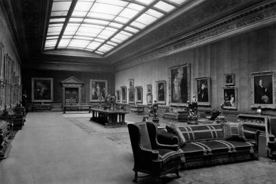 photo of gallery with paintings, seating, tables, sculptures, skylight, circa 1927