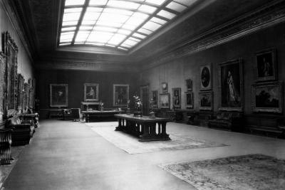 photo of gallery with paintings, skylight, tables with sculptures, circa 1927