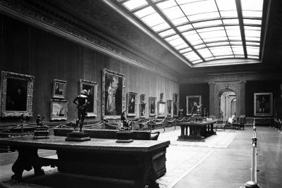 photo of gallery with paintings, skylight, tables, sculptures and barrier roping, circa 1935