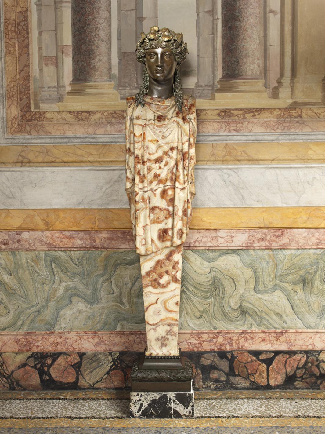 alabaster and glazed bronze sculpture of standing woman, with headdress of vines 