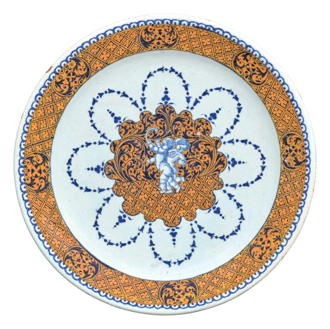 plate decorated in blue, gold and white, with two cherubs at center