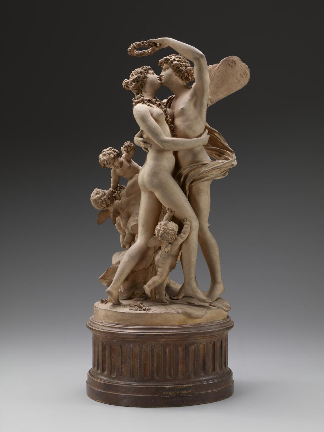 photograph of terracotta sculpture of a naked embracing couple surrounded by cupids