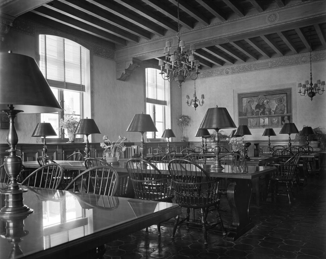Black and white photograph of the Frick Art Reference Library Reading Room taken in 1935 showing empty communal tables with lamps and chairs