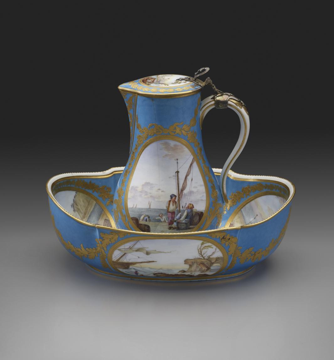 white porcelain covered water jug with basin, decorated with a blue and gold and seascape scenes