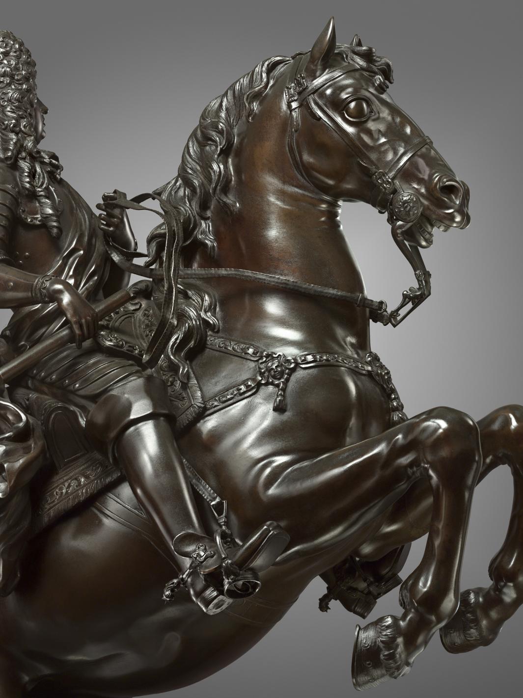 Bronze sculpture of a man on a rearing horse, close up of horse head.
