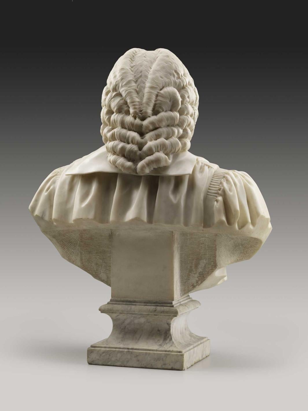 Alternate view of a marble bust of a man wearing a wig, robe, and bow-tied sash