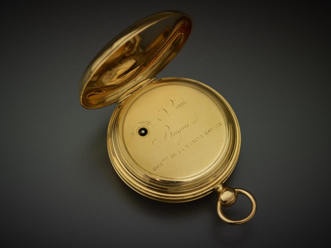 opened gold pocket watch with engraved words