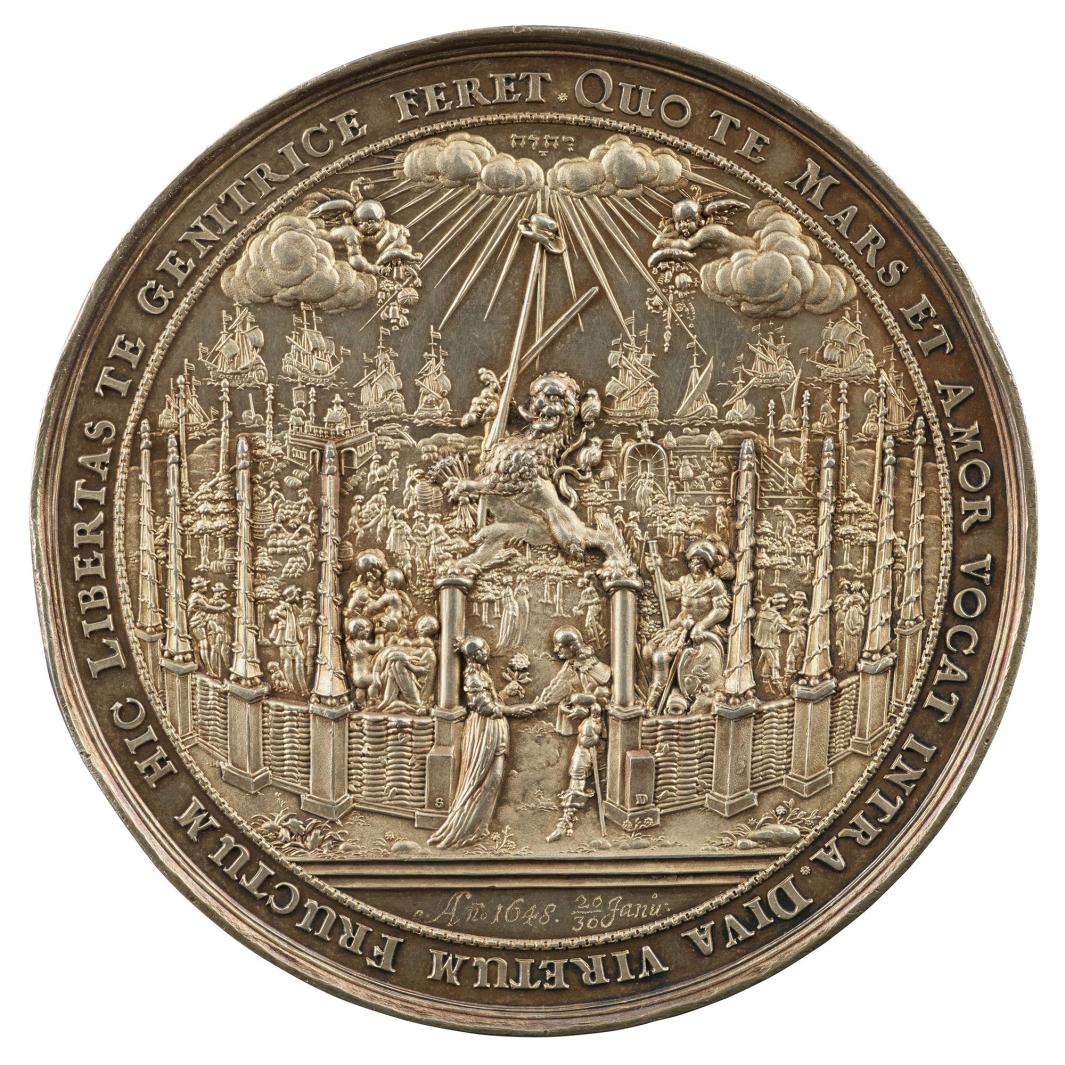 Silver medal depicting a man and woman holding hands in front of a vast landscape surrounded by a fence 