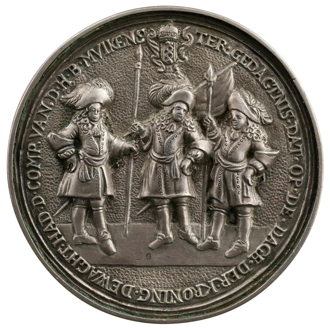 Silver medal of the captain Bernard Muikens, his lieutenant John Althusius, and his ensign Sylvester Van Tongeren of the City Guard of Amsterdam holding lances and a banner. Above, the arms of Amsterdam 
