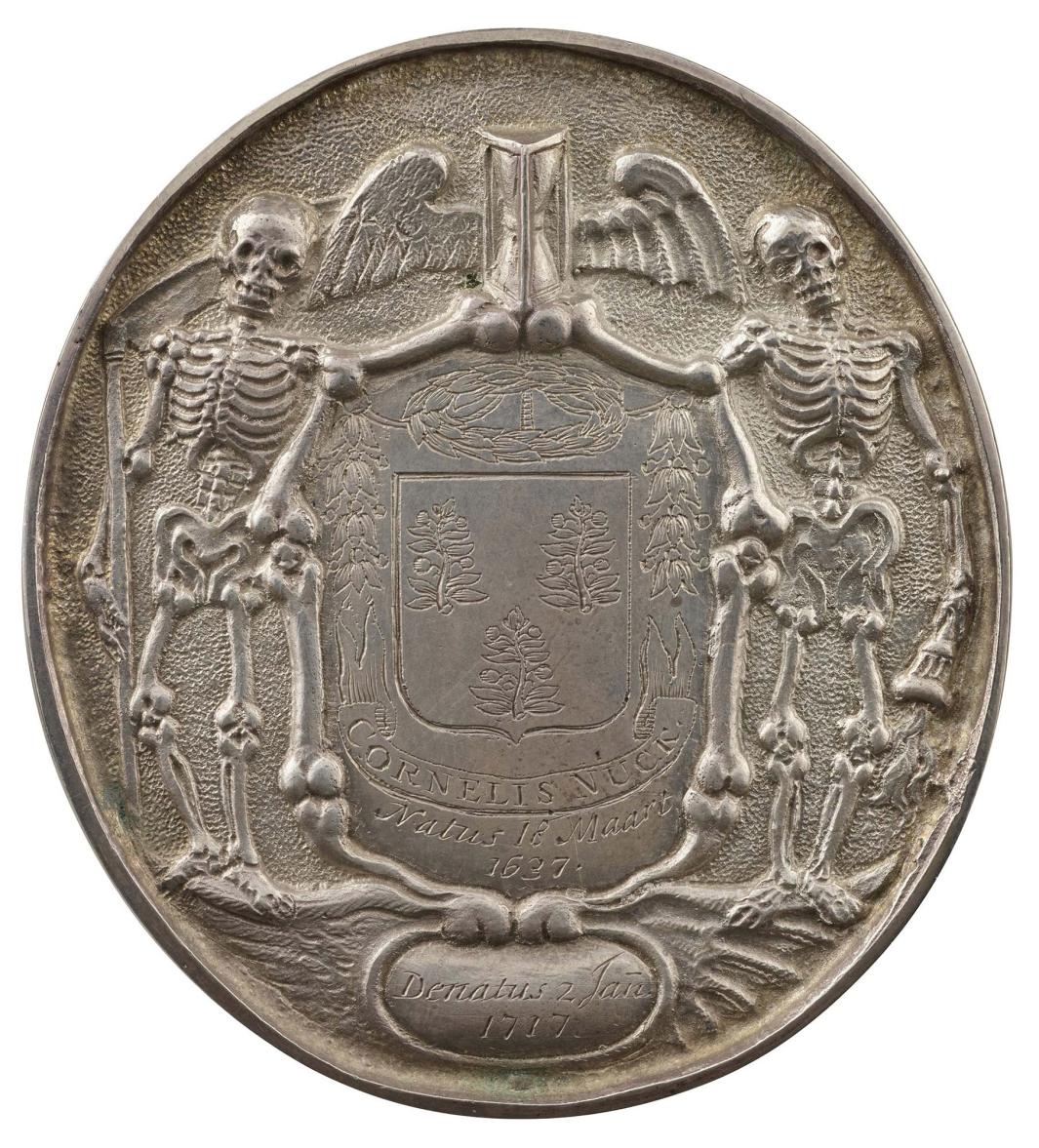 Silver medal of the laureate arms of Cornelius Nuck within a border of bones, upon which rests a winged (bat and bird wings) hourglass 