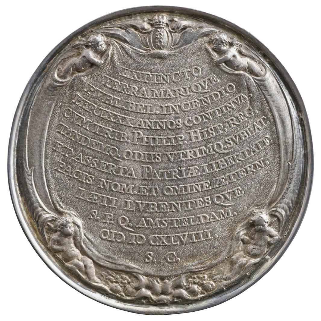 Gilt silver medal of a cloth hanging in an auricular frame with openings that contain putti, and at the bottom, various fruits; at the top, the arms of Amsterdam beneath a crown 