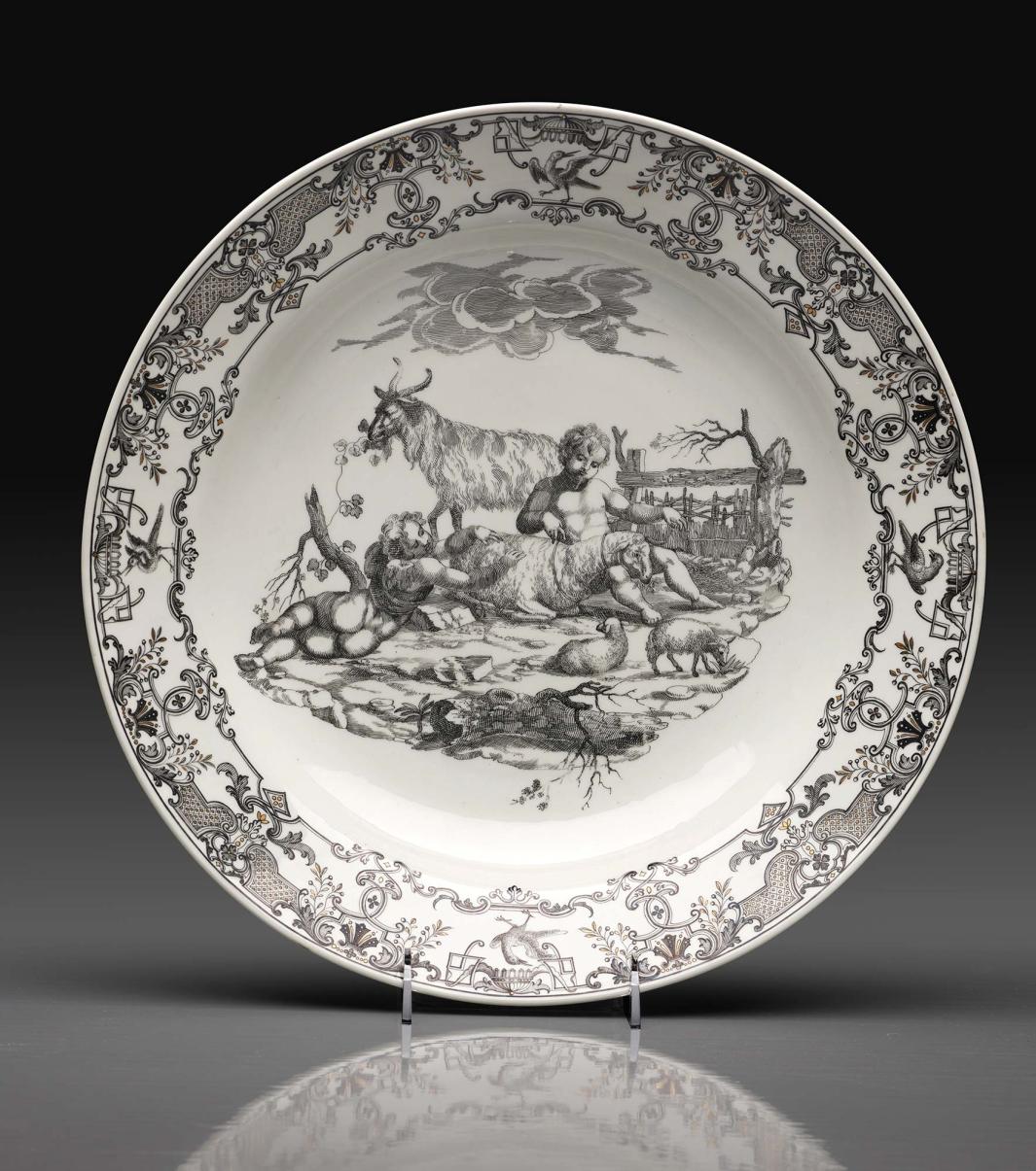 porcelain dish depicting scene of two nude youths or cherubs laying with sheep