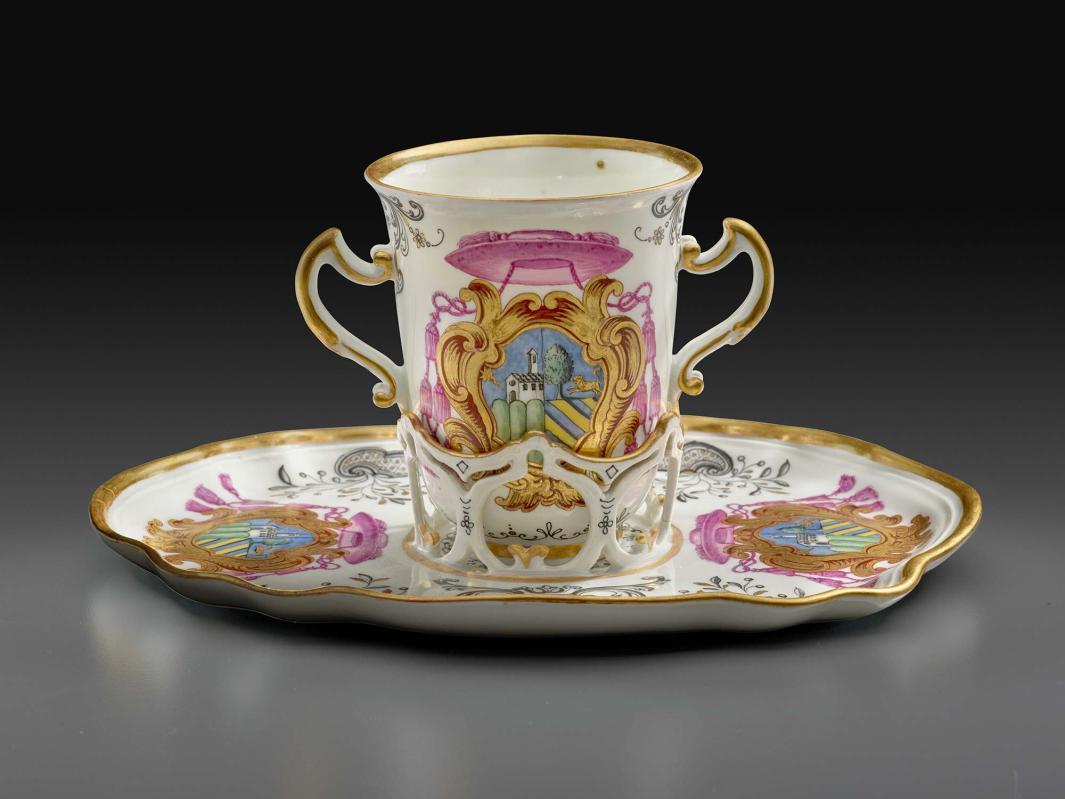 porcelain cup on saucer decorated with coat of arms