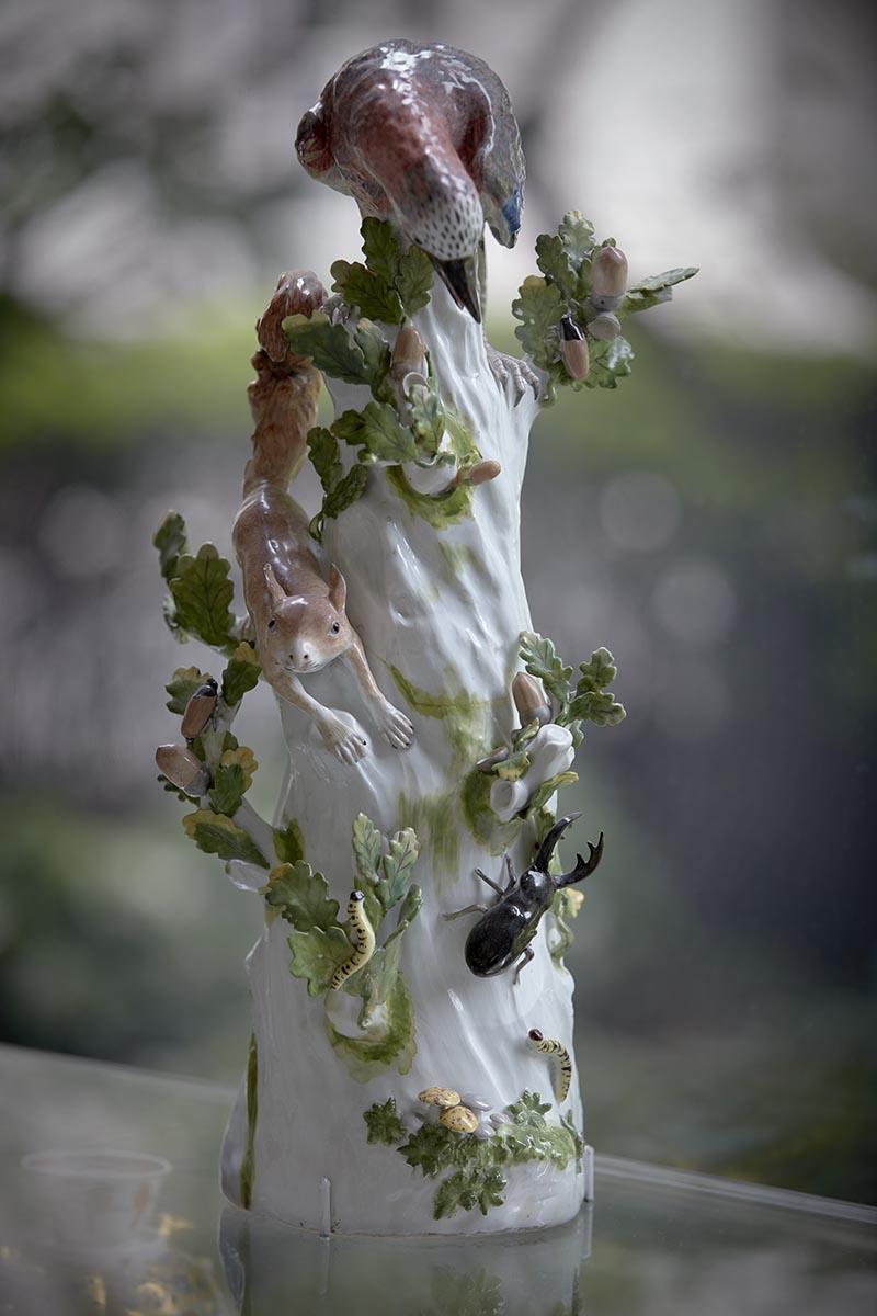 colorful porcelain depicting squirrel, bird and insects moving about branch