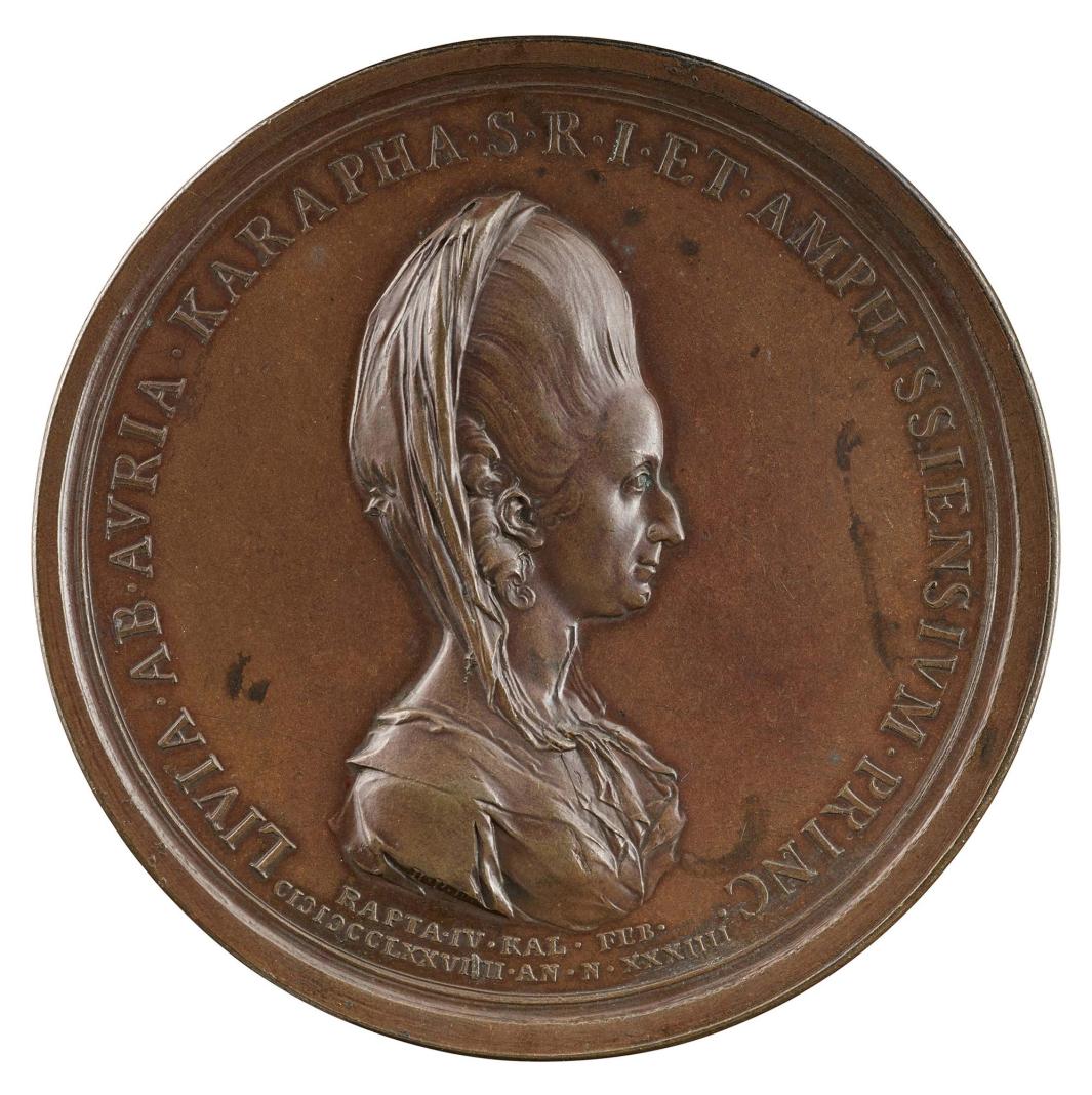 Bronze medal of a woman in profile to the right with hair styled high and draped