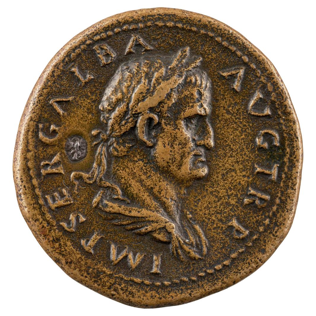 Bronze ancient Roman coin depicting Emperor Galba, crowned with laurel leaves in profile to the right, with a pearled border and an inset small silver eagle to the left of the head of the emperor.