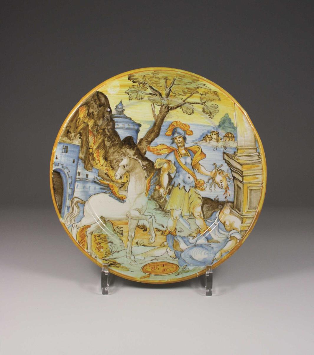 Earthenware plate with a scene of a winged horse and an armored figure holding the head of medusa while standing on her body.